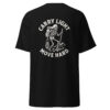 Back view of a black t-shirt featuring a bold white graphic of a skeleton hiker with a backpack, lantern, and trekking pole, standing on rocky terrain with the phrase “CARRY LIGHT MOVE HARD.” arched around the design.