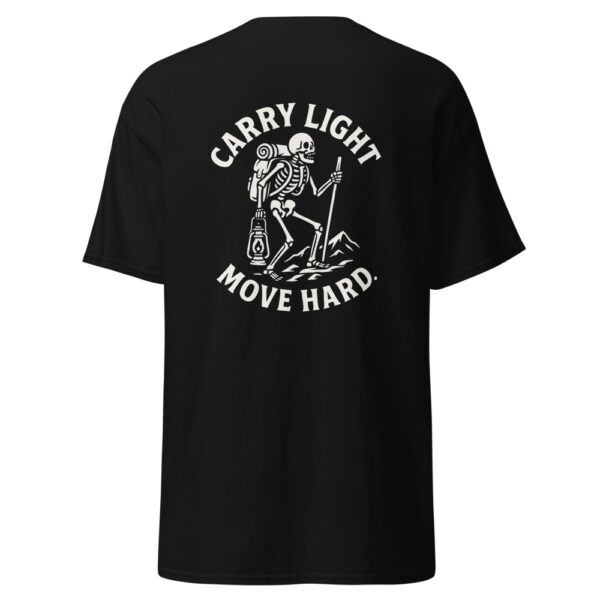 Back view of a black t-shirt featuring a bold white graphic of a skeleton hiker with a backpack, lantern, and trekking pole, standing on rocky terrain with the phrase “CARRY LIGHT MOVE HARD.” arched around the design.