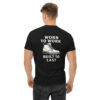 Man wearing black Varbridge t-shirt featuring rugged work boot graphic and bold text reading “WORN TO WORK – BUILT TO LAST” on the back, standing with hands relaxed