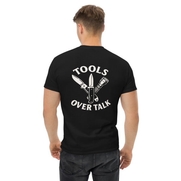 Man wearing black Varbridge t-shirt with “Tools Over Talk” back print featuring crossed knife, multi-tool, and flashlight illustration