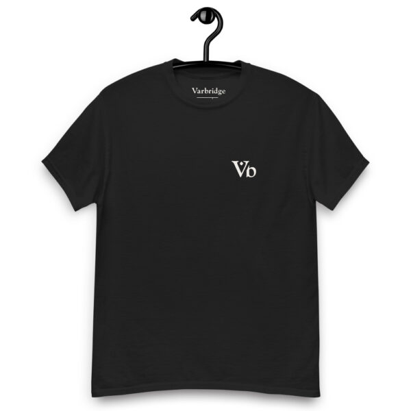 Front view of a black t-shirt hanging on a hook with a small white “Vb” Varbridge logo on the left chest.
