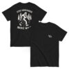 Black t-shirt with white back graphic of a Bigfoot figure walking through pine trees, surrounded by the phrase “STAY GROUNDED MOVE WILD.” Front features a minimalist “Vb” logo on the chest.