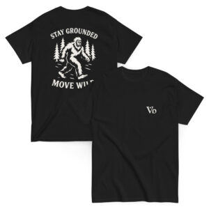 Black t-shirt with white back graphic of a Bigfoot figure walking through pine trees, surrounded by the phrase “STAY GROUNDED MOVE WILD.” Front features a minimalist “Vb” logo on the chest.