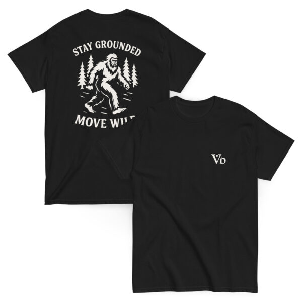 Black t-shirt with white back graphic of a Bigfoot figure walking through pine trees, surrounded by the phrase “STAY GROUNDED MOVE WILD.” Front features a minimalist “Vb” logo on the chest.