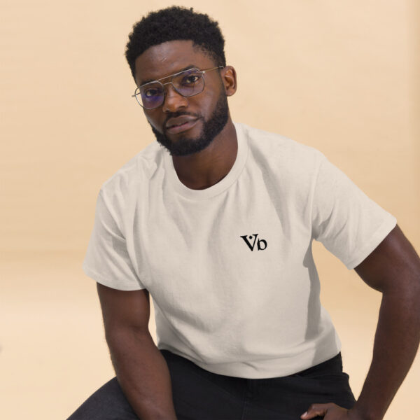 Man wearing Varbridge t-shirt with clean Vb chest logo, seated against neutral background